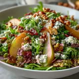 Walnuts and zesty vinaigrette add texture to the Frisée Pear Blue Cheese Bowl served fresh on a platter.