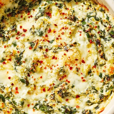 Freshly baked Spinach Artichoke Dip bubbling with golden cheese, served warm alongside crunchy tortilla chips for dipping.