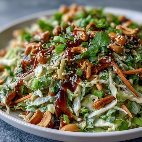 Freshly shredded green and red cabbage, julienned carrots, and cilantro tossed in a zesty Asian Cabbage Salad with sesame-ginger dressing.