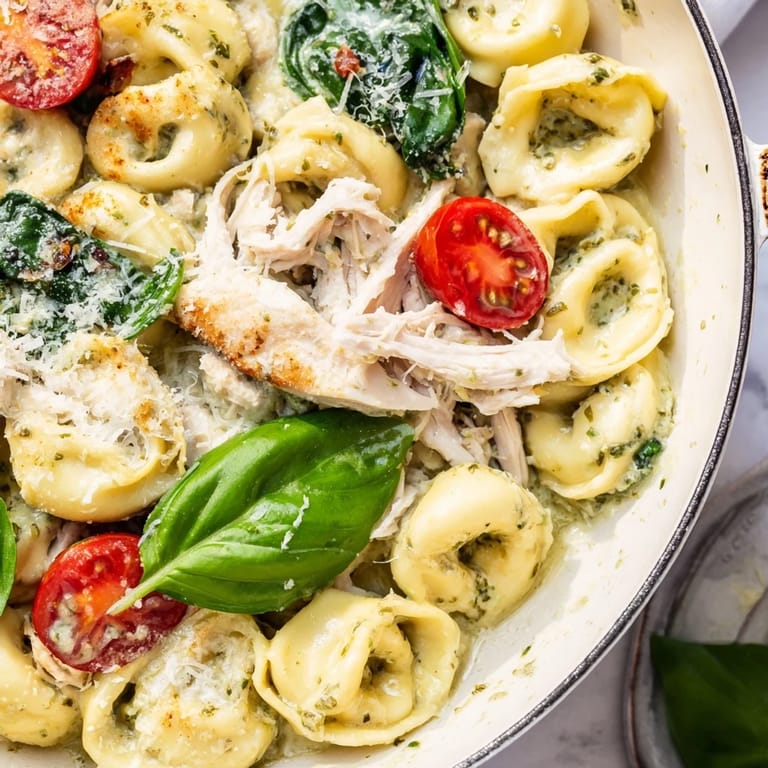 Tender cheese tortellini and shredded chicken in Creamy Pesto Tortellini Skillet, ready to serve.