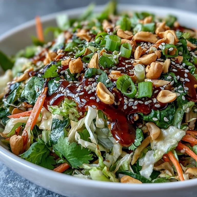 A close-up of colorful Asian Cabbage Salad featuring crisp veggies, green onions, and a glistening sesame-ginger vinaigrette, perfect for quick lunches.