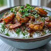 Classic New Orleans Étouffée served over fluffy white rice, garnished with fresh parsley and green onions for a vibrant dinner.