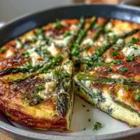 A golden Spring Veggie Frittata with asparagus, goat cheese, and fresh herbs, baked until fluffy and golden.  